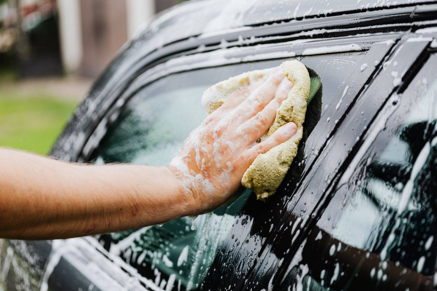 A car window being washed with a soapy sponge