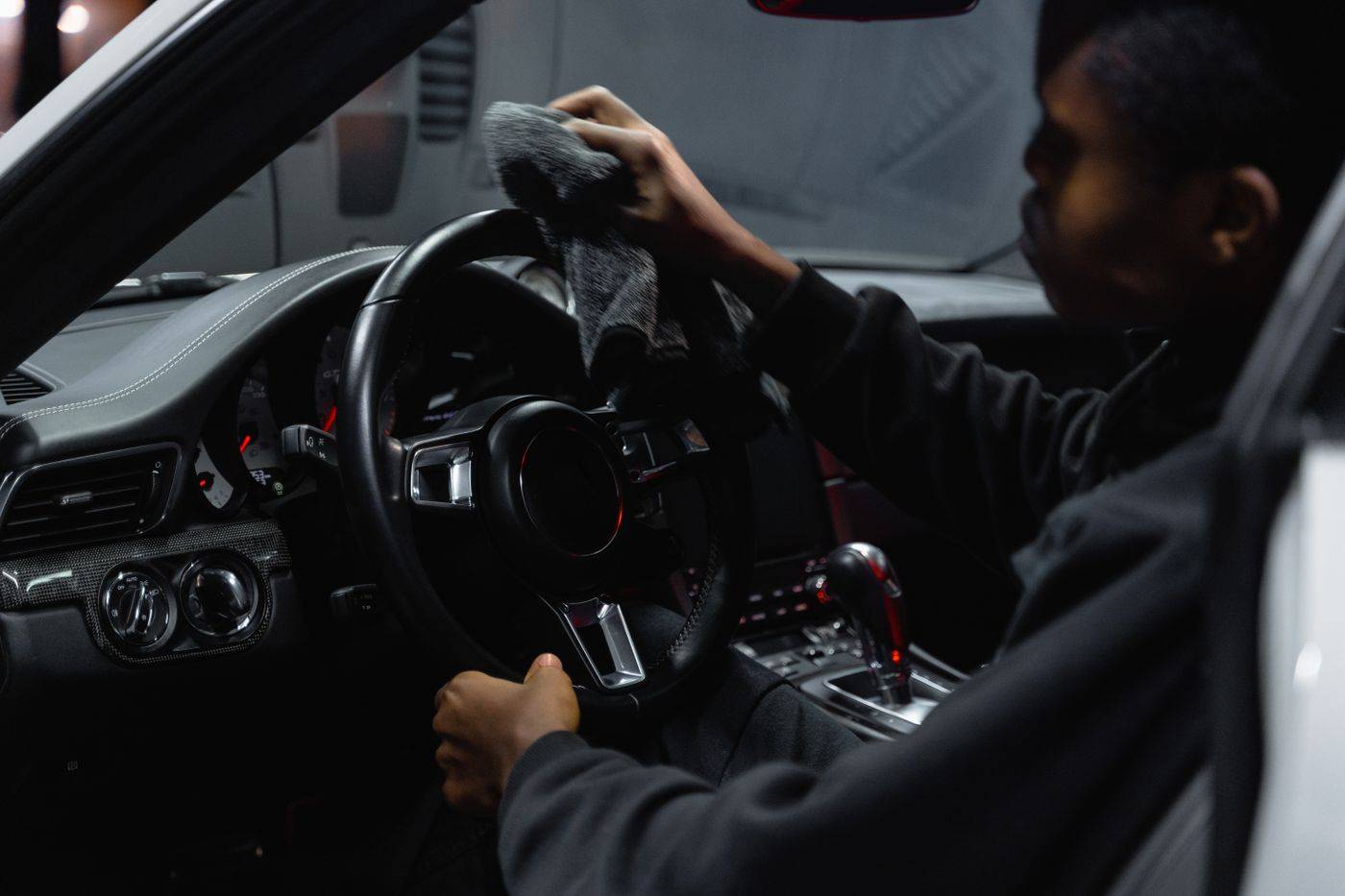 A steering wheel being wiped down with a cloth