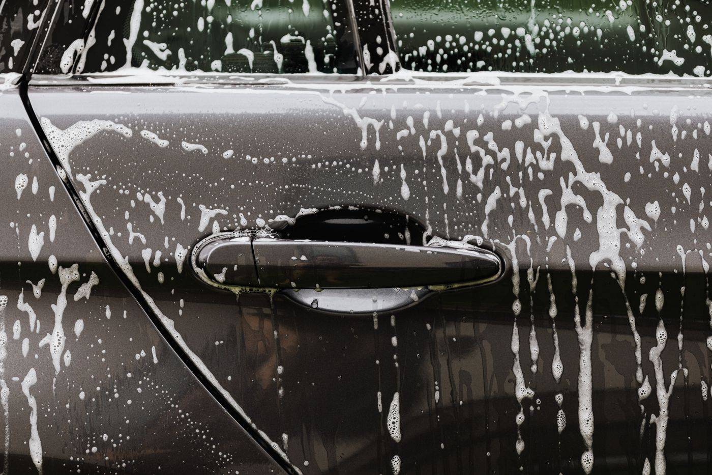 Soap suds on a car door during a hand wash