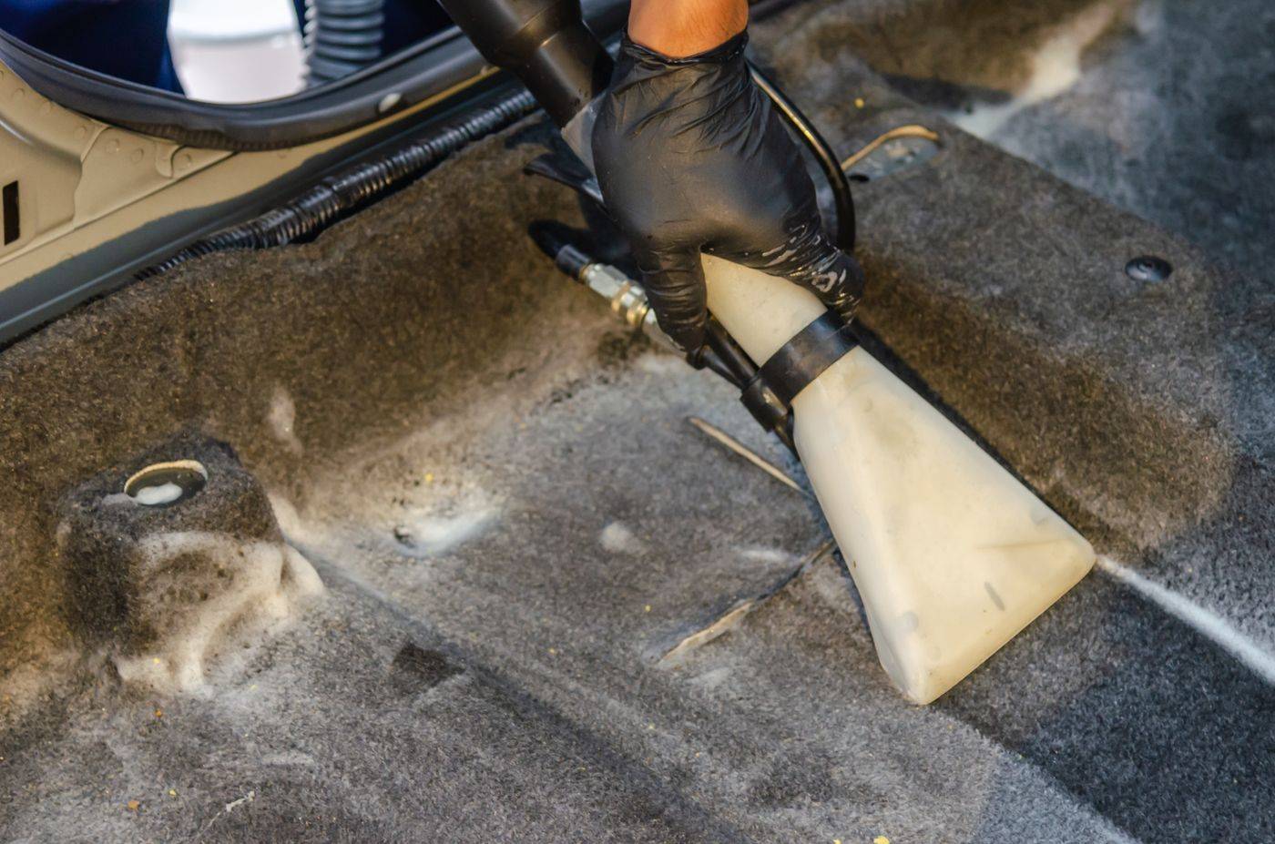 Car carpet being vacuumed