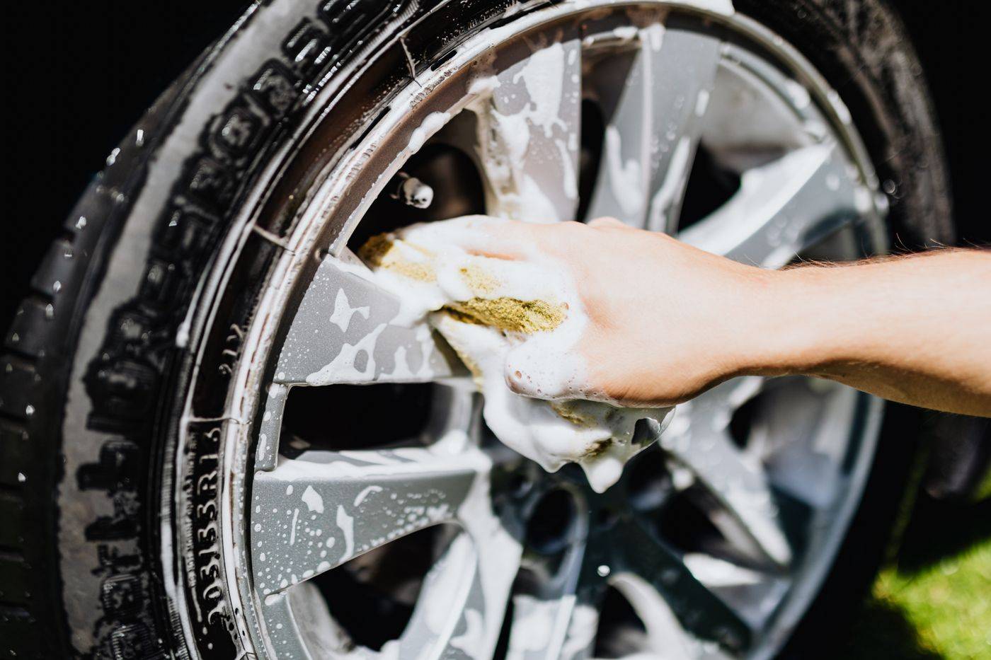 A wheel rim being scrubbed with soap suds